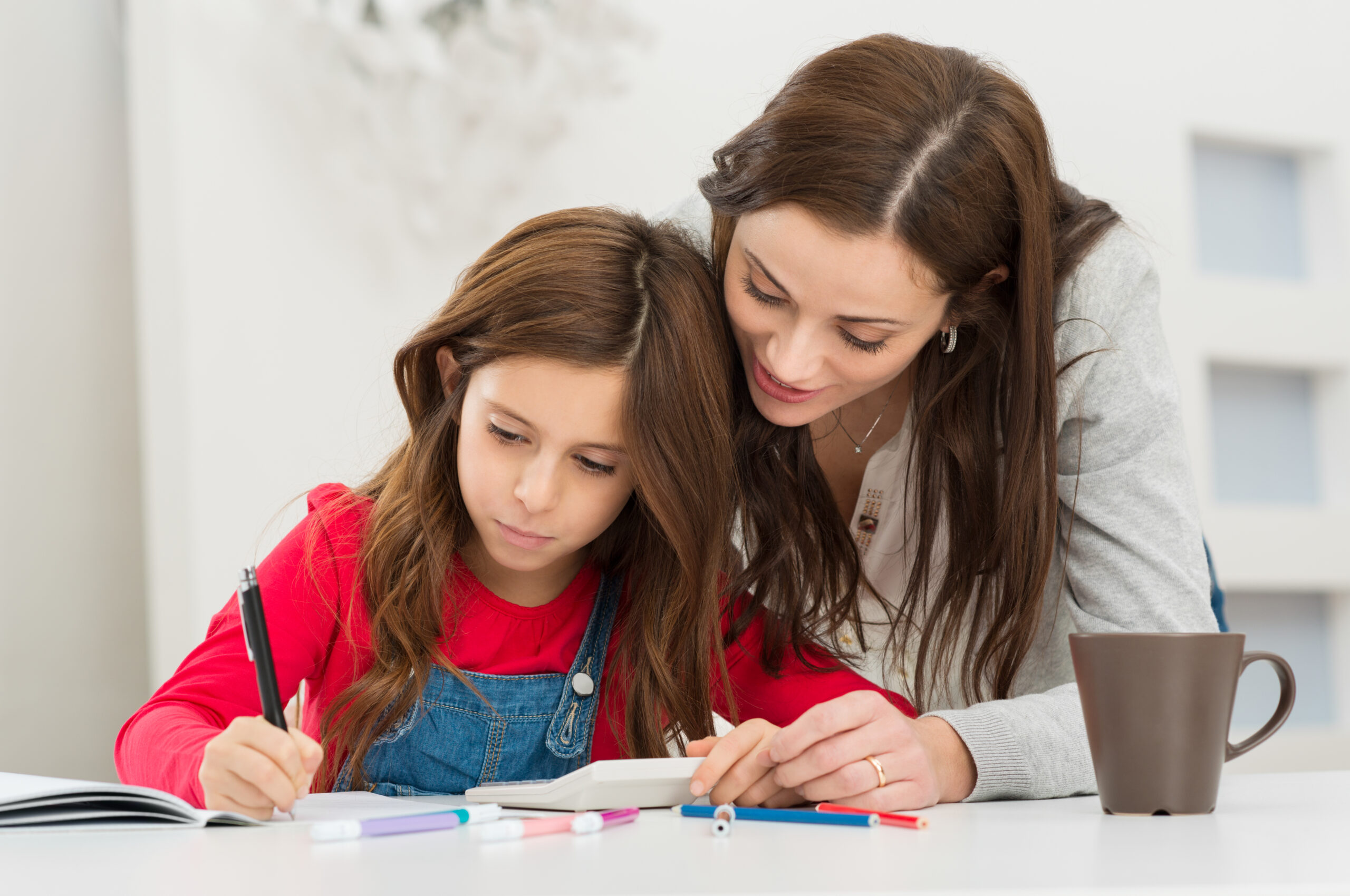 mother helping her daughter while studying scaled